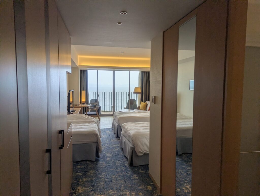 AQUA SQUAREオーシャンビュールームのツインベッドと熱海湾の眺め
