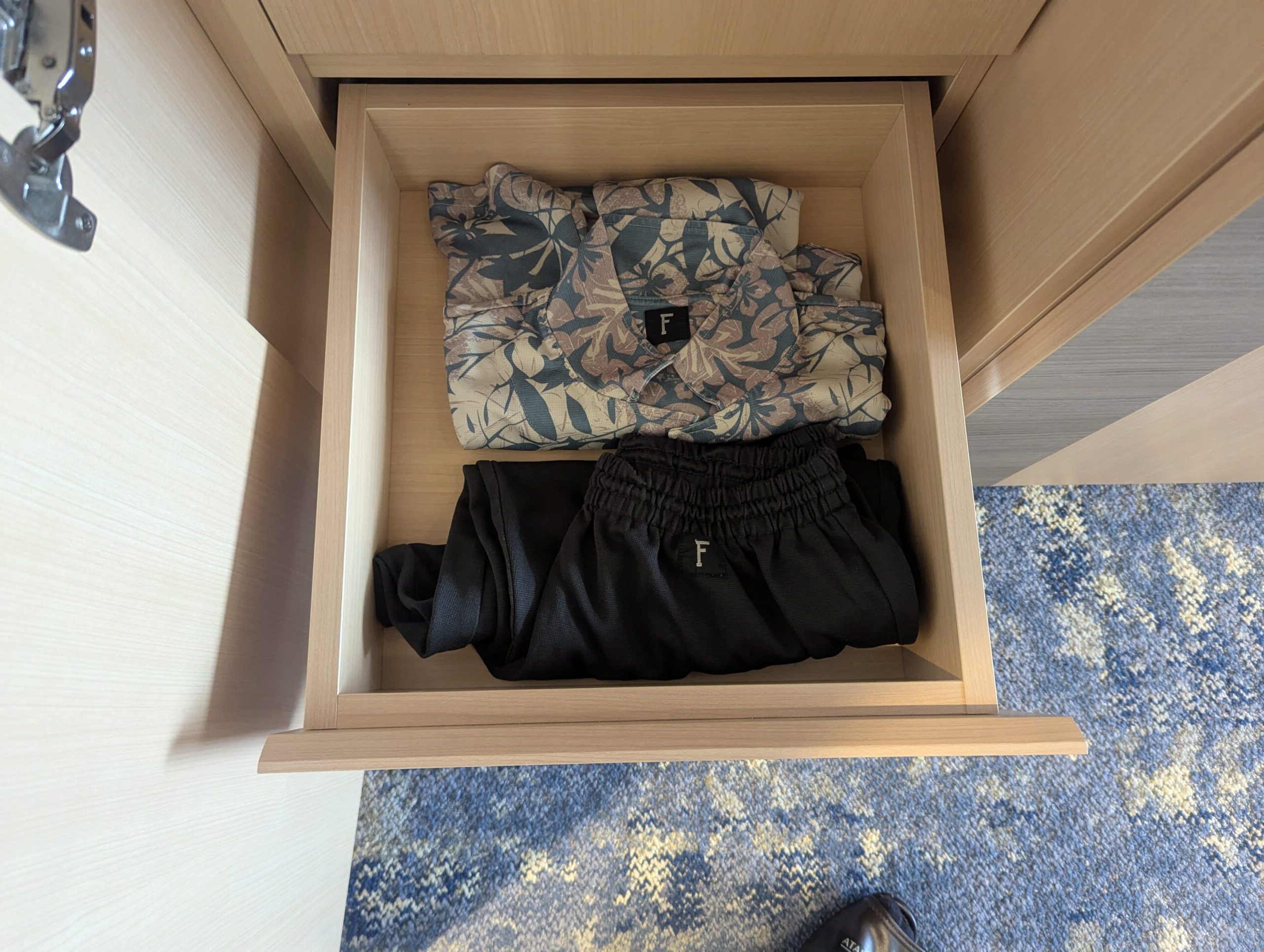 熱海後楽園ホテルAQUA SQUAREの引き出しに畳まれた館内着の柄シャツと黒パンツ