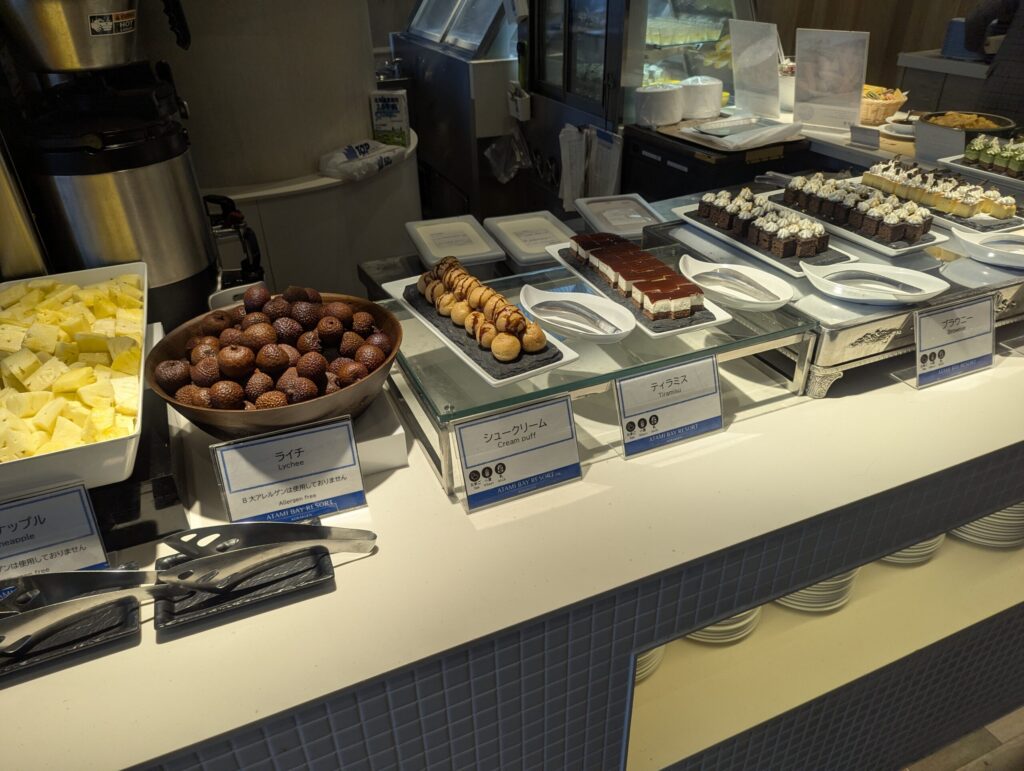 デザート棚全景・パイナップル・ライチ・シュークリーム・ティラミス・ブラウニーが一列に並ぶ