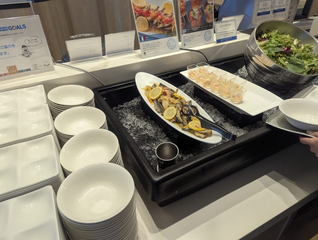 ミックスオリーブ・ブルスケッタ2段盛り・丹那牛乳胡麻ムースが並ぶ洋前菜ライン全景、春の地中海フェアPOPも見える