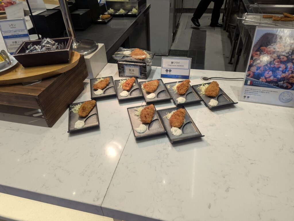 鯵フライ（Fried horse mackerel）が小分けの黒い小皿9皿に並び、タルタルソース添え