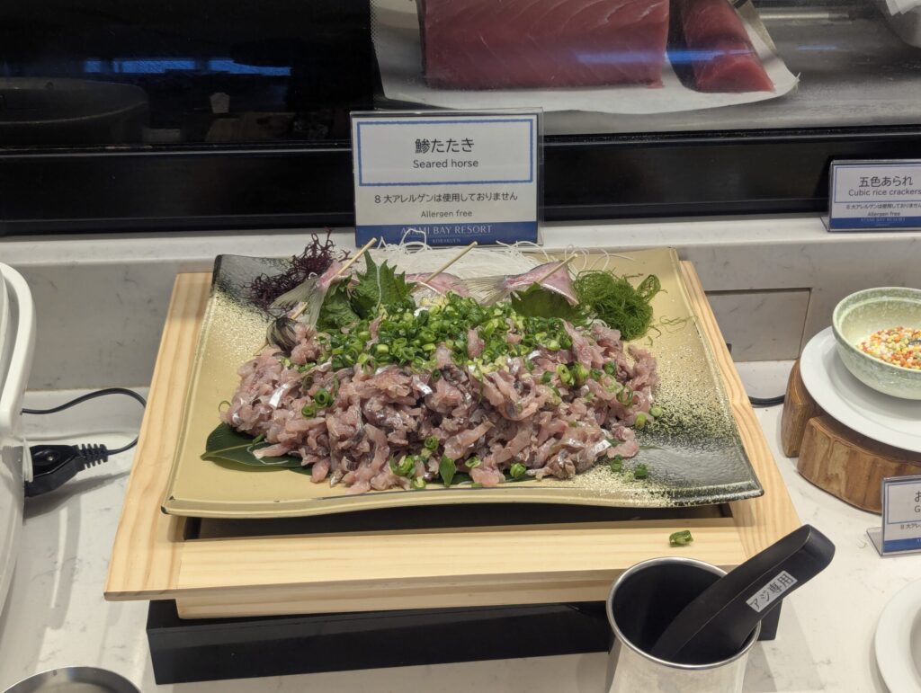 山盛りの鯵たたき・ネギと大葉を添えて金色の大皿に盛られている