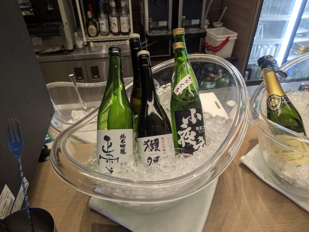 日本酒「正雪 純米吟醸」「獺祭 純米大吟醸45」「小夜衣 地酒工房」の3本が氷バケットに挿さり、右端にPol Messè