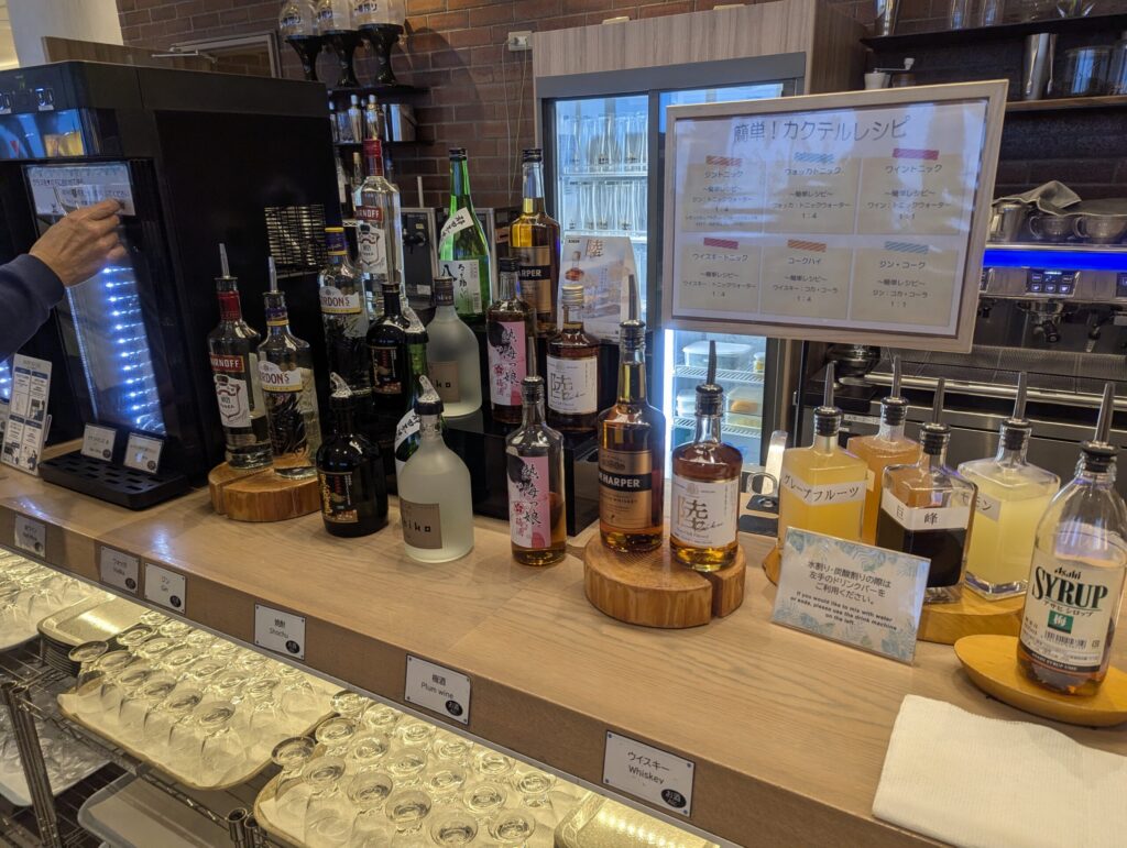 ウイスキー・ジン・焼酎・シロップが並ぶセルフカクテルバーとレシピ表