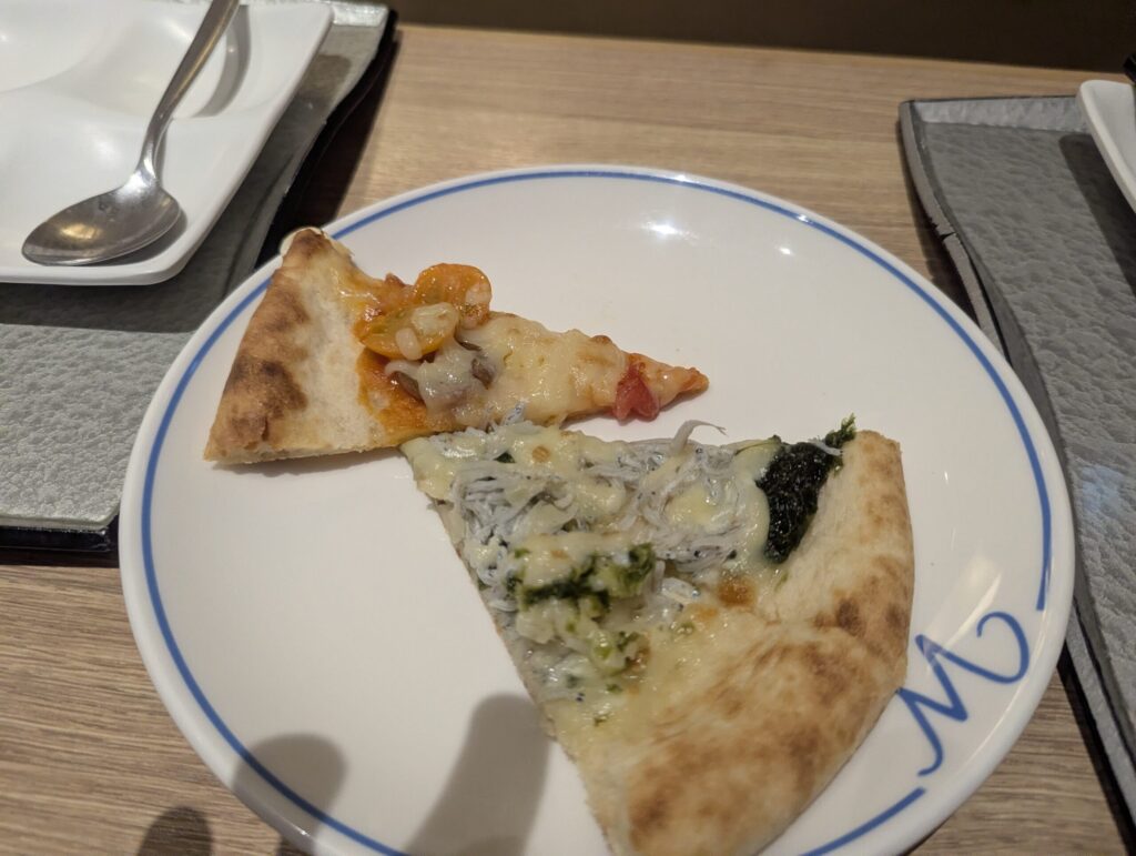 1枚の白皿にマルゲリータ1切れとしらすピザ1切れが盛られている