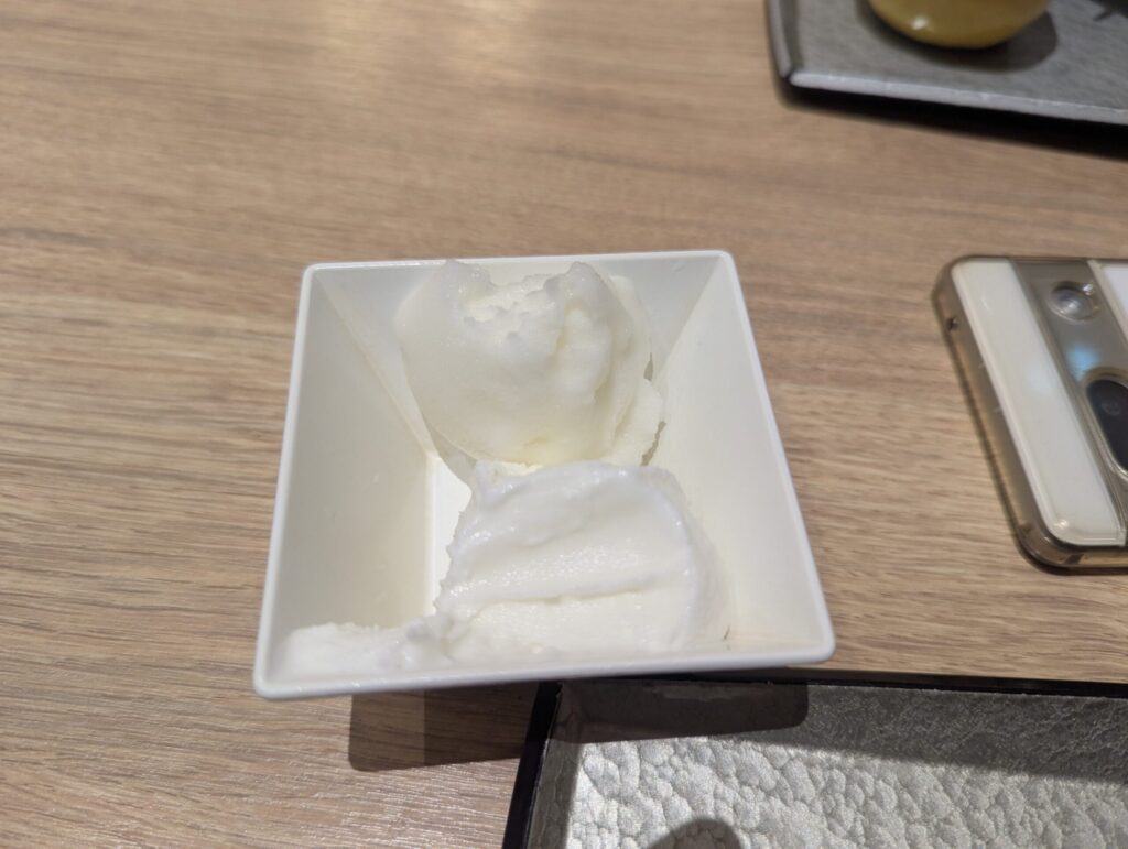 白い四角小皿に盛られたヨーグルト風シャーベット・スマートフォンが横に写る