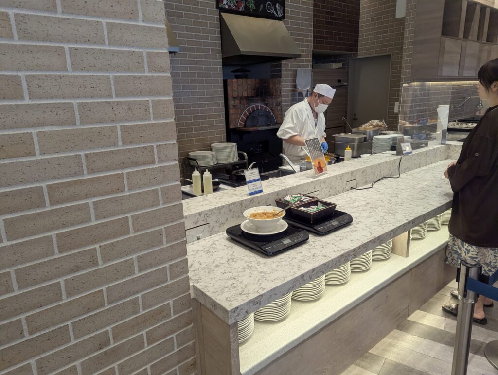 熱海後楽園ホテル朝食のライブキッチンで調理中の白衣シェフ