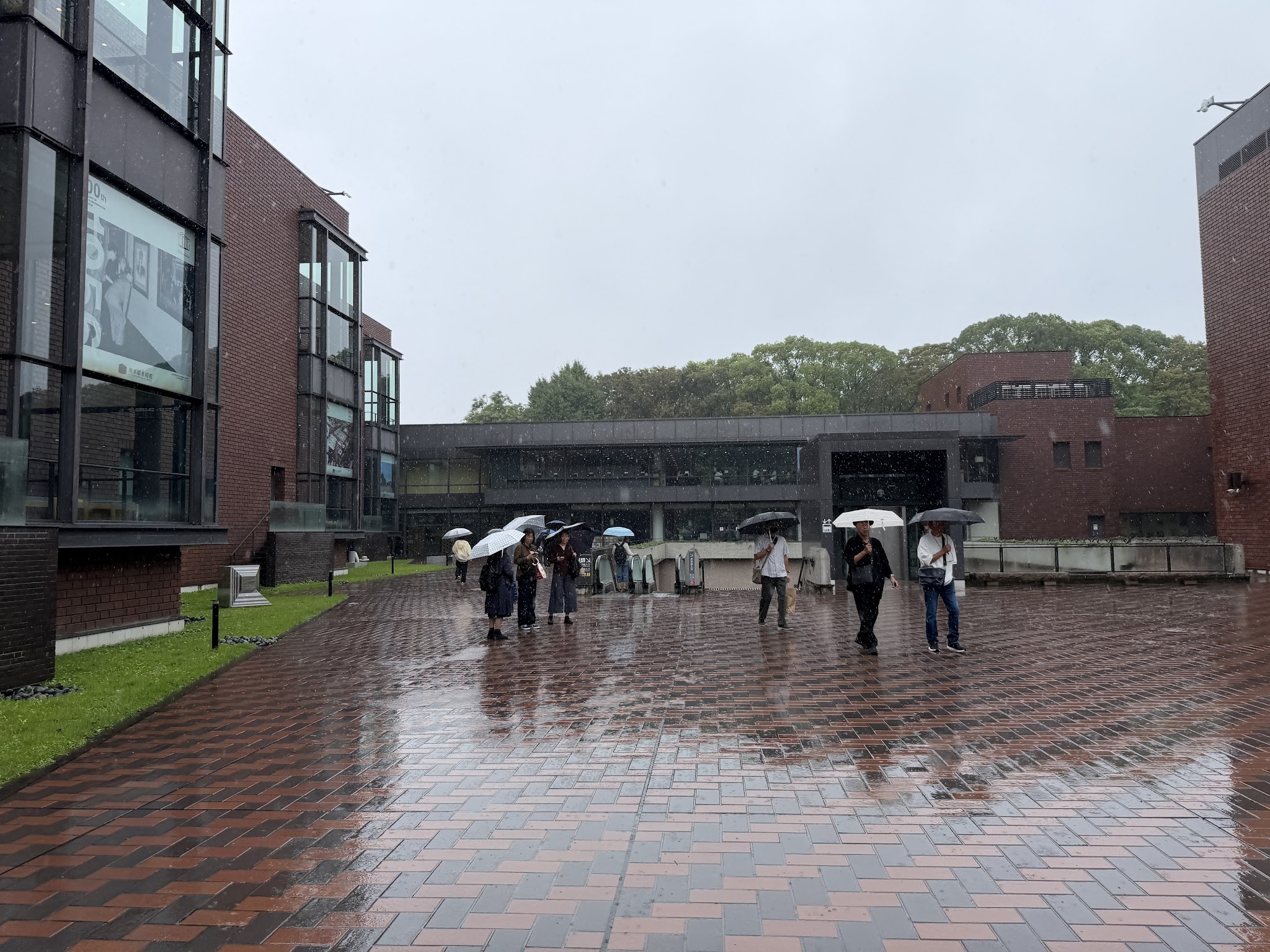 雨の日の東京都美術館の外観と入口へ向かう広場