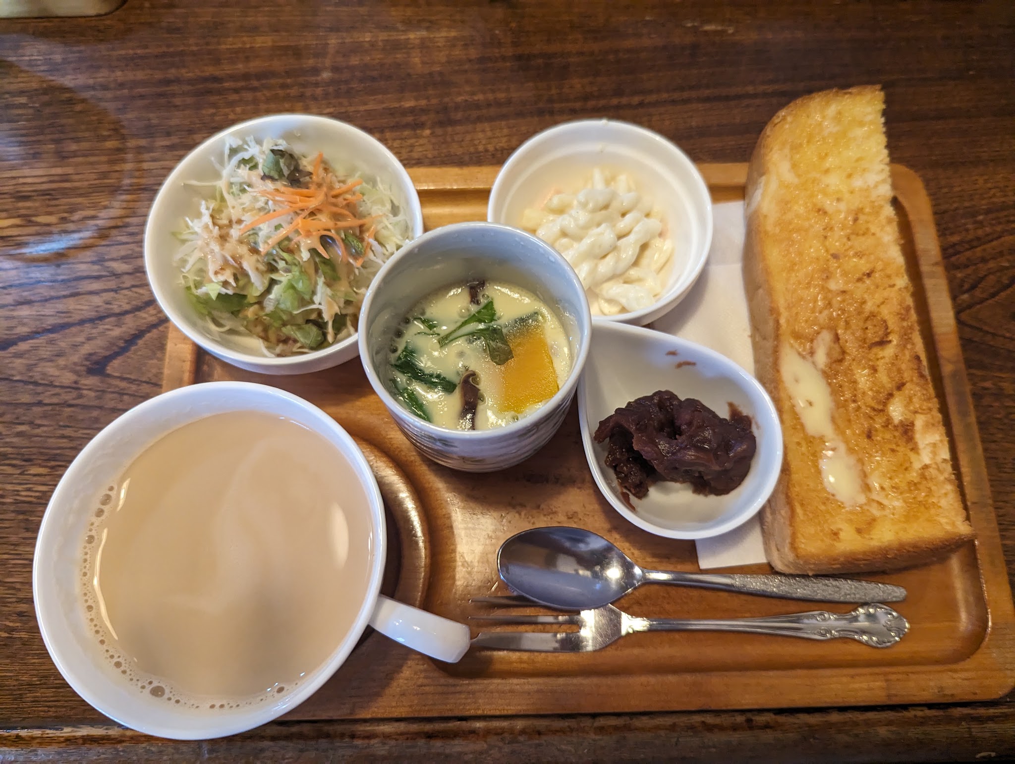 トーストとサラダ、小鉢、飲み物が並ぶモーニング