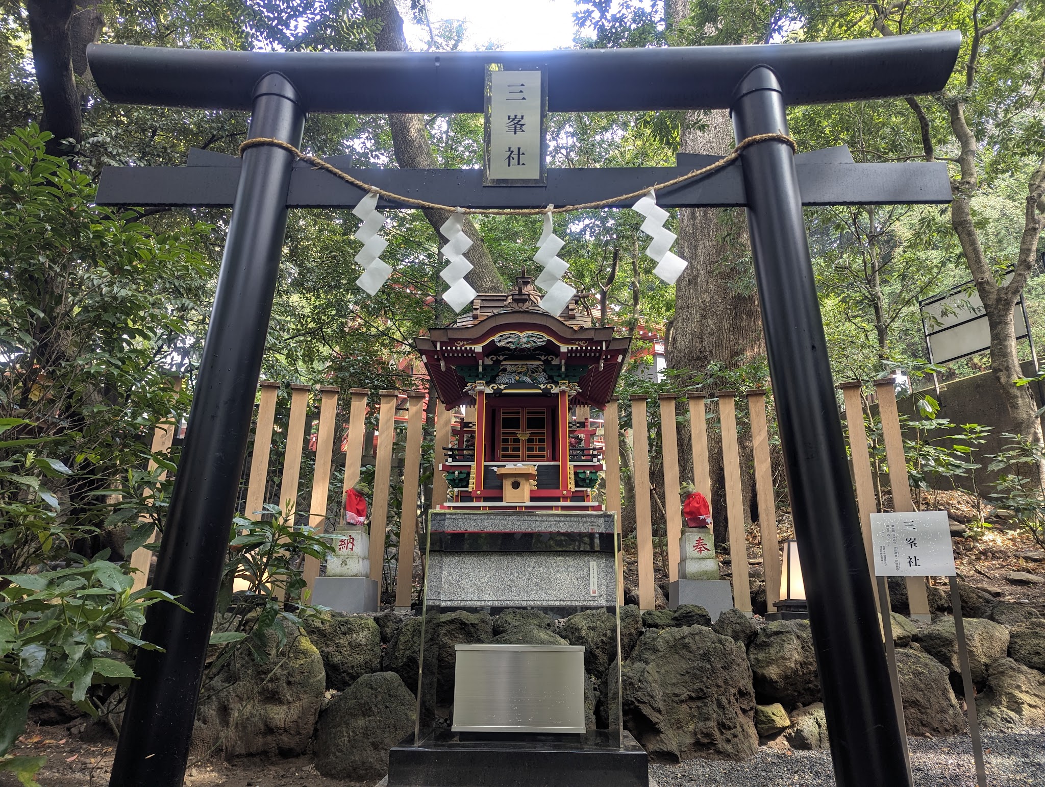 三峯社の黒い鳥居と赤い社を正面から見た様子