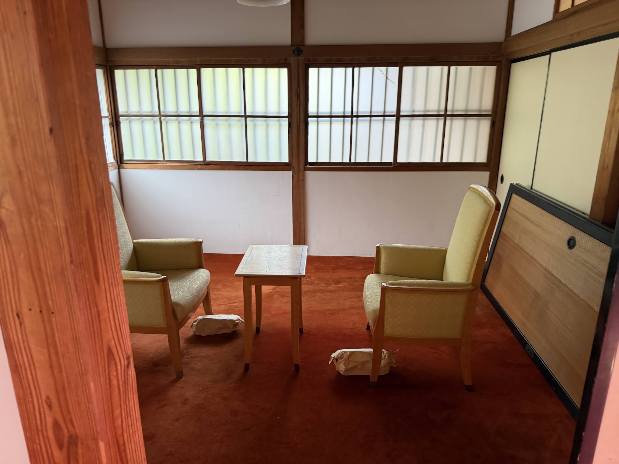 向かい合う二脚の椅子と小さなテーブルがある一室
