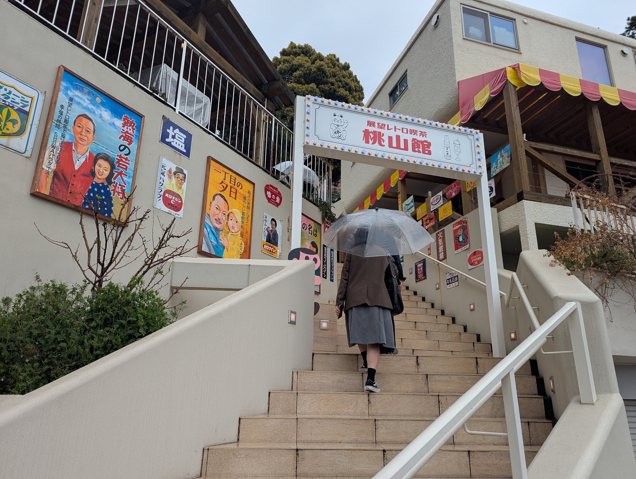 傘を差した来館者と入口の階段