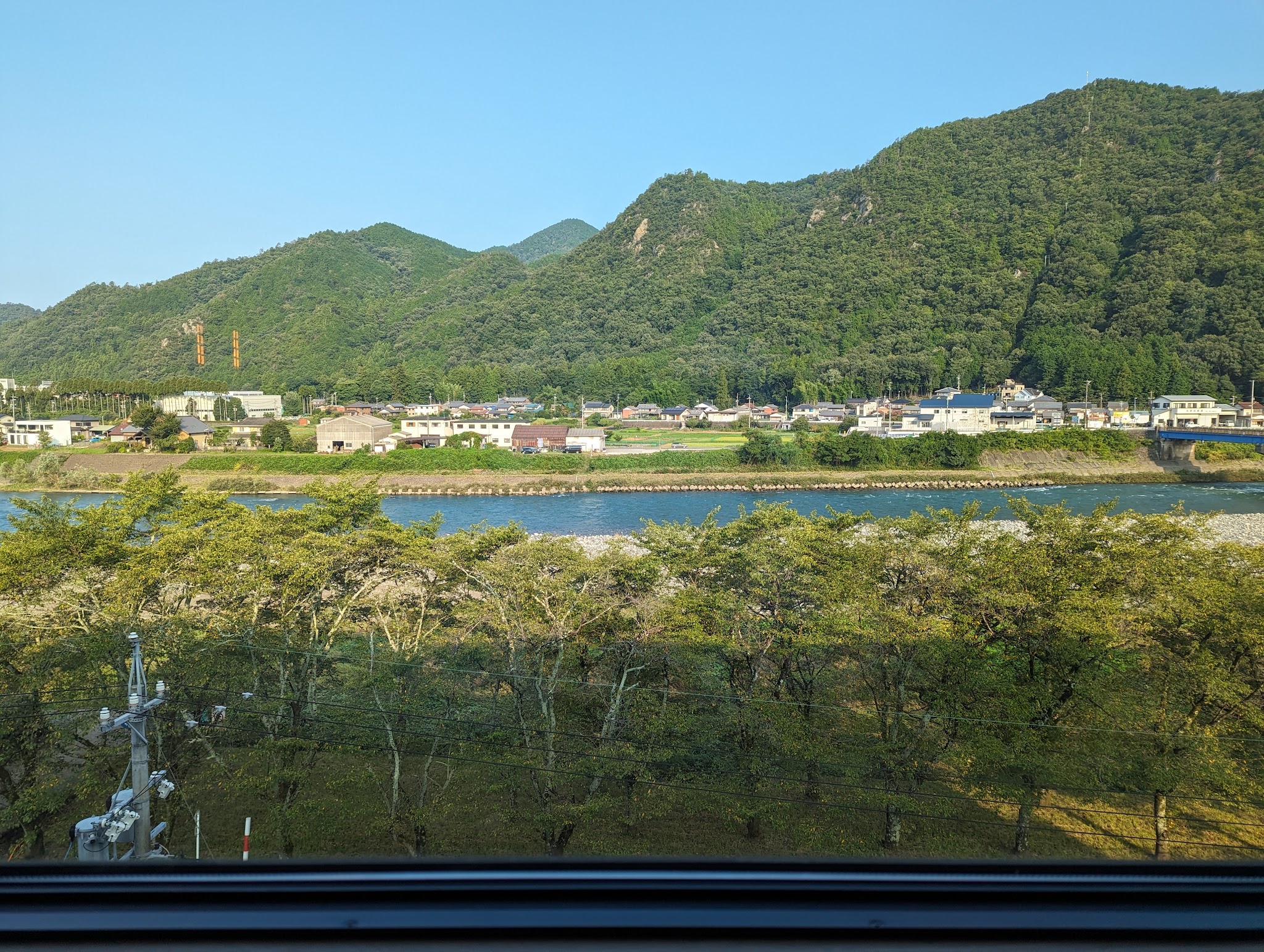 客室の窓越しに見える長良川と緑の山