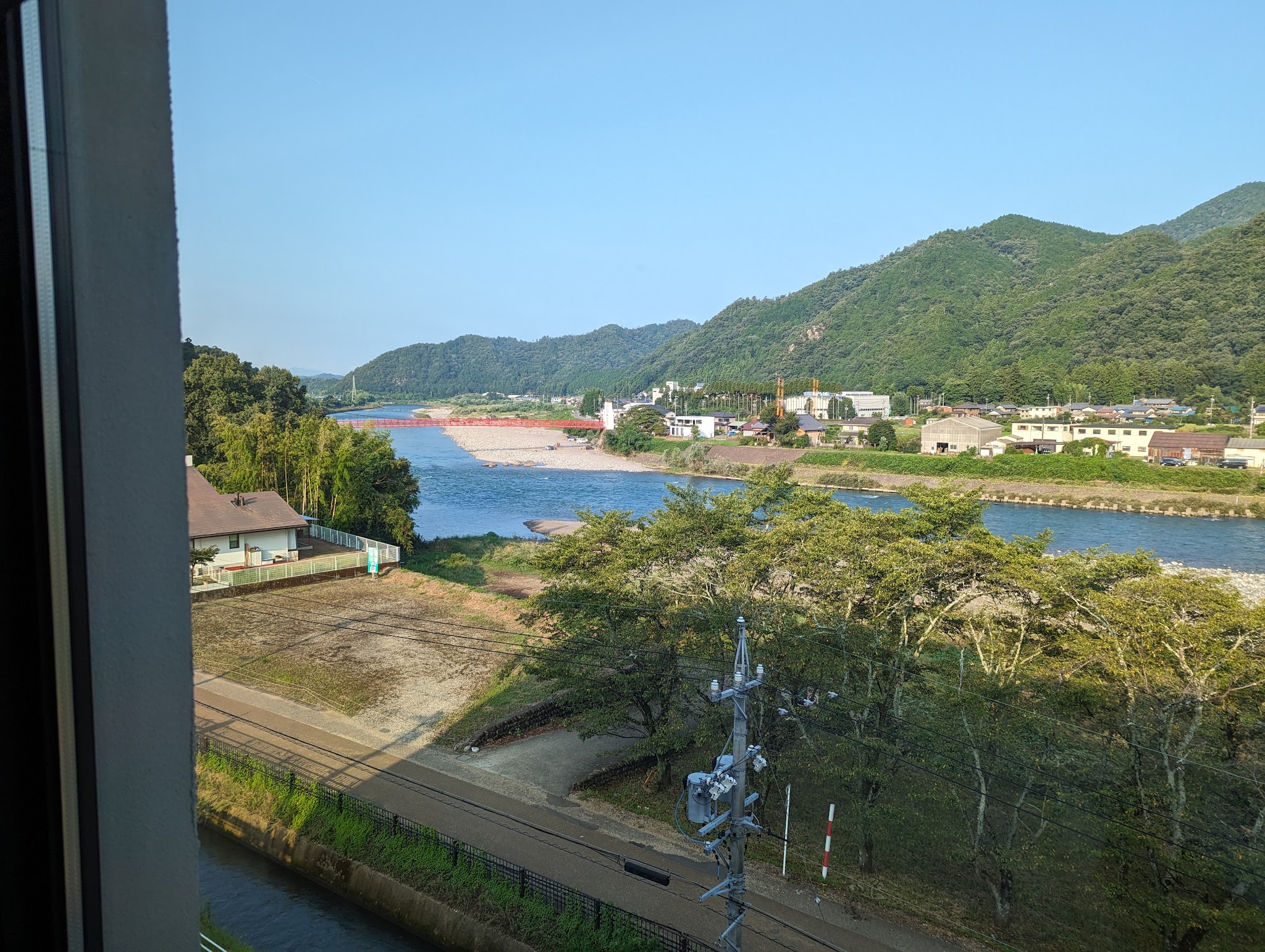 窓から斜めに眺めた長良川と橋のある風景