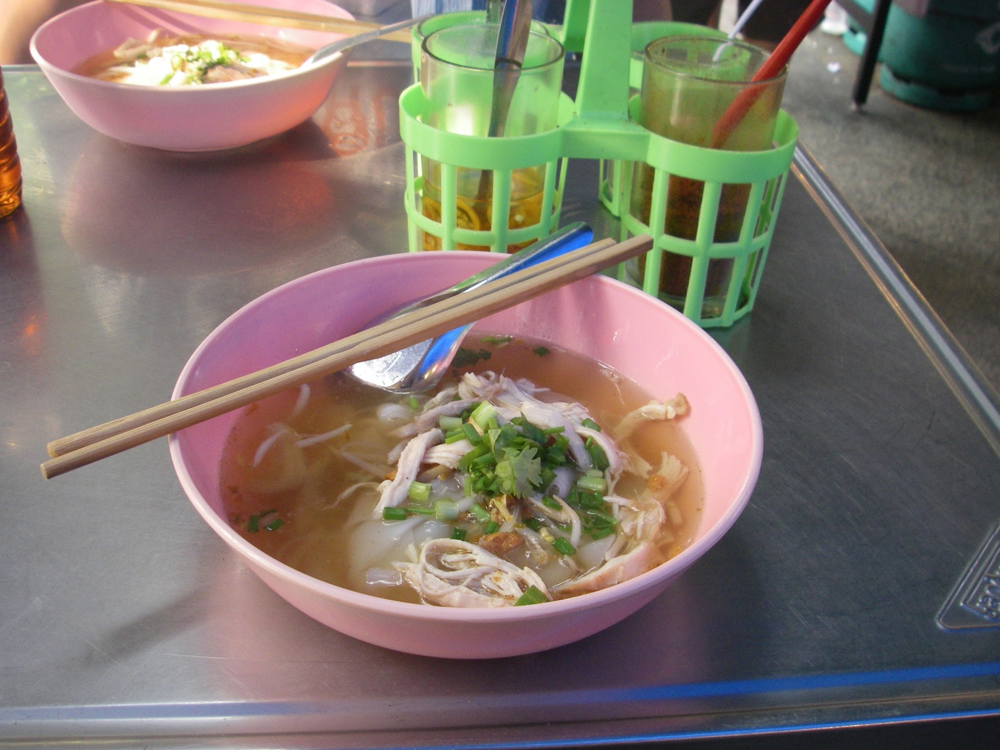 ピンクの器に入った、フォーのような米の麺のスープ
